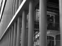 A prison guard keeps his eyes on the activity down below from the top level of the jails inner cube.  The Bristol County Jail and House of Correction on Ash St. in New Bedford, MA was built in 1829 and is the oldest operating jail in the country.  Almost all of the inmates at the jail are awaiting trial date.  Eighteen of the inmates have been sentenced and are active in the maintenance of the facility.