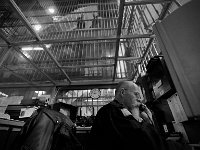 Officer Doug Rankin speaks on the phone in the central control room with a glass ceiling as inmates look down from above.  The Bristol County Jail and House of Correction on Ash St. in New Bedford, MA was built in 1829 and is the oldest operating jail in the country.  Almost all of the inmates at the jail are awaiting trial date.  Eighteen of the inmates have been sentenced and are active in the maintenance of the facility.