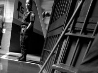 An officer looks on as an inmate mops the floor.  The inmates that are serving sentences are given maintenance tasks throught the jail.  The Bristol County Jail and House of Correction on Ash St. in New Bedford, MA was built in 1829 and is the oldest operating jail in the country.  Almost all of the inmates at the jail are awaiting trial date.  Eighteen of the inmates have been sentenced and are active in the maintenance of the facility.