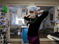 ICU nurse, Jennifer Souza, prepares herself to go into a sealed room with a patient on a ventilator infected with COVID-19 at St. Luke's Hospital in New Bedford.  PHOTO PETER PEREIRA