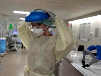 RN Amanda Larson, puts on her protective gear, before going into a room containing a COVID-19 patient at St. Luke's Hospital in New Bedford.  PHOTO PETER PEREIRA