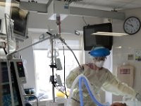 Amanda Larson, RN, checks in on a patient infected with COVID-19 patient at St. Luke's Hospital in New Bedford.  PHOTO PETER PEREIRA]