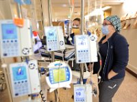 Dialysis technicians, Ashley Whalen and Melissa Lemieux, keep their eye on their patient who is in a sealed room reserved for COVID-19 patients at St. Luke's Hospital in New Bedford.  PHOTO PETER PEREIRA