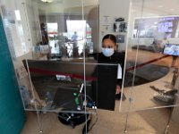 In the window to the left, an EMS crew is seen leaving with a stretcher, as the desk staff in the Emergency Department is now protected by clear glass from patients at St. Luke's Hospital in New Bedford.  [ PETER PEREIRA/THE STANDARD-TIMES/SCMG ]