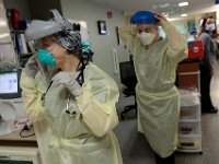Two ER put on their protective gear before speaking with a newly admitted patient in the Emergency Room at St. Luke's Hospital in New Bedford.  The patient is placed in a sealed room, and approached with the same gear as one infected with COVID-19, until it is established that he/she does not have it.  PHOTO PETER PEREIRA
