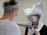 Injury prevention specialist, Stephanie Hart, performs an N95 mask fitting test to RN Kelly Burke at St. Luke's Hospital in New Bedford. The fitting test is performed with any front line worker dealing with COVID-19 patients.  PHOTO PETER PEREIRA]