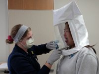 Injury prevention specialist, Beth Lemieux, performs an N95 mask fitting test to RN Natasha Chen at St. Luke's Hospital in New Bedford. The fitting test is performed with any front line worker dealing with COVID-19 patients.  PHOTO PETER PEREIRA
