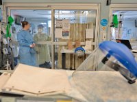 Respiratory therapist, Jennifer Candido, left, speaks with the nurses inside one of the sealed rooms used for COVID-19 patients in Knowles Wing at St. Luke's Hospital in New Bedford.  PHOTO PETER PEREIRA