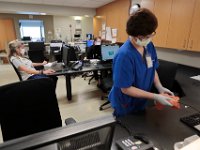 Housekeeping staff continuously clean the nurses station, in the background Sally Graham, RN can be seen checking in on her patients profile in the WIlkes Wing at St. Luke's Hospital in New Bedford.  [ PETER PEREIRA/THE STANDARD-TIMES/SCMG ]