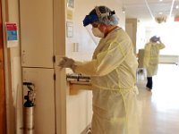 Tony Dias, RN prepares to go into a room to check in on a patient infected with COVID-19 at St. Luke's Hospital in New Bedford.  PHOTO PETER PEREIRA