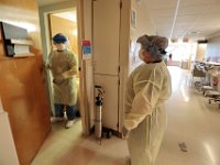 RN Tony Diaz, left, and nurse assistant, Ana Santos, prepare to check in on a COVID-19 patient in the Crapo Wing at St. Luke's Hospital in New Bedford.  PHOTO PETER PEREIRA