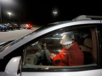 A shopper tries to stay warm and entertain himself in his vehicle as he waits for JC Penney to open at midnight on Black Friday in Dartmouth, MA.  [ PETER PEREIRA/THE STANDARD-TIMES/SCMG ]