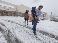 A family exits Shaws in Dartmouth as a snow storm sweeps across the area.  [ PETER PEREIRA/THE STANDARD-TIMES/SCMG ]