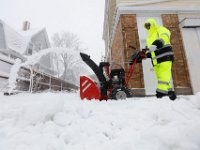 A man uses a snowblower to clear the sidewalk on Rotch Street in New Bedford as a snow storm sweeps across the area.  [ PETER PEREIRA/THE STANDARD-TIMES/SCMG ]