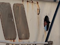 1007935253 ma nb Fishing  The captain of the F/V United States, Antonio Cravo, takes a peek out of a porthole to see if his crew is ready to unload their catch at Bergie's Seafood in New Bedford.   PETER PEREIRA/THE STANDARD-TIMES/SCMG : fishing, waterfront, fisherman, boat, catch, fish