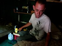 ma nb HomelessinTheWoods  James Soares, 50, reads the bible inside the room he has made from crates in the woods behind Save Rite in the north end of New Bedford.  PETER PEREIRA/THE STANDARD-TIMES : poverty, homeless, woods