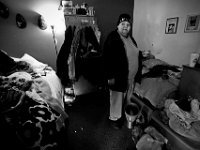 After waking up, Tracy Trembley opens up a can of cat food to feed the house cat, Laverne, at the House of Hope in New Bedford. The House of Hope houses over 50 homeless people and has self  quarantined for over two weeks due to the coronavirus pandemic.  No one is allowed in or out of the shelter.  PHOTO PETER PEREIRA