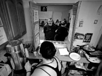 House of Hope residents line up to grab coffee and a light breakfast, outside the kitchen window. The House of Hope houses over 50 homeless people and has self  quarantined for over two weeks due to the coronavirus pandemic.  No one is allowed in or out of the shelter.  PHOTO PETER PEREIRA