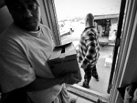 Residents of the House of Hope in New Bedford, form a chain to unload the just arrived food donations sent by the Broken Chains Biker Church in Taunton. The House of Hope houses over 50 homeless people and has self  quarantined for over three weeks due to the coronavirus pandemic.  No one is allowed in or out of the shelter.  PHOTO PETER PEREIRA