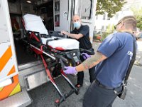 New Bedford EMS paramedic supervisor and Kevin Agrella pull the stretcher from the ambulance at a call for a man having difficulty breathing.  Despite over 12,000 COVID-19 related calls since March, only one part-time EMT has tested positive for the virus.  PHOTO PETER PEREIRA