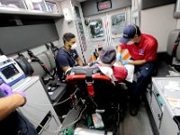 New Bedford EMT, Ivan Britto, left, and Dan Goodman, paramedic student, tend to a man complaining of difficulty breathing in the back of the ambulance before transporting him to the hospital. Despite over 12,000 COVID-19 related calls since March, only one part-time EMT has tested positive for the virus.   PHOTO PETER PEREIRA