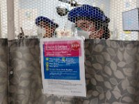 Farren Flemming, tech, and Catelyn Dube, nurse, speak from behind the curtain where a possible COVID-19 positive patient was just admitted to the Charlton Memorial Hospital in Fall River.  PHOTO PETER PEREIRA