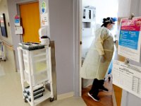 Nursing assistant, Nicole Paul makes her way into the room of a COVID-19 positive patient in the Atwood Wing at the Charlton Memorial Hospital in Fall River.  PHOTO PETER PEREIRA