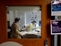 Sara St.Amour RN, check on a COVID-19 patient as her assistant Maria Alves stands by at the Charlton Memorial Hospital in Fall River.  PHOTO PETER PEREIRA