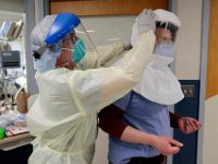 David Scola, radiology tech, wipes down the PAPR hood of Dr. Hector Mateo after he left the room with a COVID-19 patient at the Charlton Memorial Hospital in Fall River.  PHOTO PETER PEREIRA