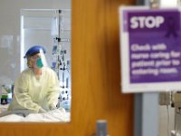 Sara St.Amour RN, check on a COVID-19 patient as her assistant Maria Alves stands by at the Charlton Memorial Hospital in Fall River.  PHOTO PETER PEREIRA