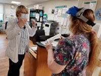 Nursing manager, Tina Jones, explains the proper way to fit the visor to Sue Spalding RN at Tobey Hospital in Wareham.  PHOTO PETER PEREIRA