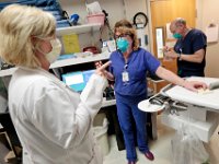 (l to r) Nurse manager, Deb Gonsalves, speaks with Betty Chandler RN about a newly admited patient as Brian Lenahan RN is seen in the background in the ER of Tobey Hospital in Wareham.  PHOTO PETER PEREIRA