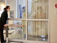 Katie Akley speaks through the glass to Michaelle Efthimiades inside a room containing a COVID-19 positive patient at Tobey Hospital in Wareham.  PHOTO PETER PEREIRA