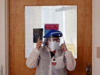 Phlebotomist, Carmen Fitzgerald, puts on a mask as she heads into a room with a COVID-19 possible patient at Tobey Hospital in Wareham.  PHOTO PETER PEREIRA