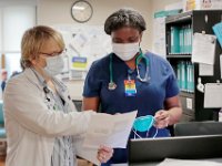 Tina Jones, nursing manger, outlines the proper way to label her fitted mask to Oshetisi Okagbare RN inside the SK2 wing of Tobey Hospital in Wareham.  PHOTO PETER PEREIRA