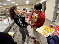 Maria Santos helps seventh grader Nevaeh DeMello, 12, clean her shirt after some watermelon juice fell on it during one of the six lunch periods at the Normandin Middle School in New Bedford.  [ PETER PEREIRA/THE STANDARD-TIMES ]