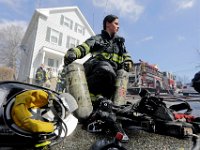 Jolene Menard, only one of two woman firefighter in the New Bedford fire department, helps fellow firefighters with their air tanks as they respond to a fire on Spruce Street.  This is par of a series I am working on.  [ PETER PEREIRA/THE STANDARD-TIMES ]