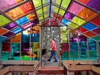 Mike Mooney walks past one of the colorful greenhouses at the Haskell Gardens on Shawmut Avenue in New Bedford.  [ PETER PEREIRA/THE STANDARD-TIMES/SCMG ]