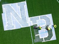 New Bedford DPI's Felix Fernandez leads John Burgo, Arthur Correia & Danny Ortiz re-painting the large NB letters inside the center circle of the soccer field at Riverside Park in the north end of New Bedford.  [ PETER PEREIRA/THE STANDARD-TIMES/SCMG ]