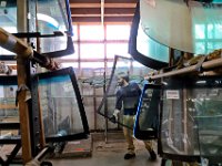 Steve Coelho walks past the huge inventory of glass, with a new windshield in hand for a repair he is performing at the Glaer Glass shop on Purchase Street in New Bedford, MA on  April 10, 2019.