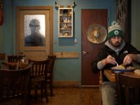 A patron of No Problemo in downtown New Bedford, MA enjoys lunch as a shadow figure can be seen passing behind a door's glass pane in the back of the dining area on January 23, 2019.