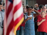 Students salute the flag during the playing of the National Anthem during the annual Veternas Day ceremony held at the Roosevelt Middle School in New Bedford, MA on November 8, 2019.