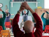 Instructor, Joey Machado, conducts a chair yoga session with seniors at the Haxelwood Senior Center in New Bedford, MA.  The low impact yoga sessions, which are held twice a week, are popular with the city's senior community offering them the ability to perform yoga while sitting.