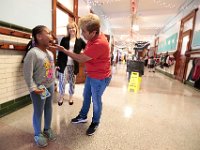 First grader, Azouraa Williams, 6, is eager to show John B. Devalles Elementary School custodian Susana Martins, that she her tooth fell overnight and was recompensed by the tooth fairy. [ PETER PEREIRA/THE STANDARD-TIMES/SCMG ]