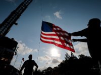 Joe Costa, left, and Acushnet firefighter, Michael Mentzer, hoist an American flag to fly above the 9/11 memorial in front of the Acushnet Fire Station at the intersection of Main Street and Russell Street in Acushnet.  [ PETER PEREIRA/THE STANDARD-TIMES/SCMG ]