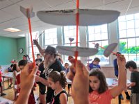 Ed the Wizard has attendees hold up their plane to check on how the group is proceeding during his Rocket and Airplane Building Workshop held at the Acushnet Public Library as part of a grant from the Acushnet Cultural Council.  [ PETER PEREIRA/THE STANDARD-TIMES/SCMG ]