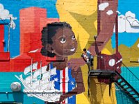 David Guadalupe paints the beads on the woman's bracelet as he works on a mural with a Cape Verdean theme,  painted on the side of the Bisca Club on Acushnet Avenue in the south end of New Bedford.  [ PETER PEREIRA/THE STANDARD-TIMES/SCMG ]