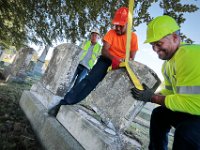 Ceemtery foreman, William Days, left, looks on as Gary Magnet, and John Souza struggle to place the toppled headstone back on its base at the Oak Grove Cemetery in New Bedford where seven gravestones were toppled.   [ PETER PEREIRA/THE STANDARD-TIMES/SCMG ]