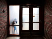 Elwyn Campbell Elementary school students playing during recess, are seen through the frosted windows on the doors inside the polling station, hosted by the school during elections. [ PETER PEREIRA/THE STANDARD-TIMES/SCMG ]