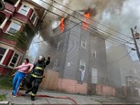 A New Bedford firefighter rescues a woman who was sleeping on the second floor of a three residence building which caught fire on Clark Street in New Bedford. The woman was taken in an ambulance for smoke inhalation.  [ PETER PEREIRA/THE STANDARD-TIMES/SCMG ]